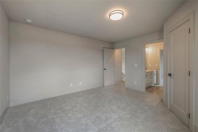 unfurnished bedroom with baseboards, visible vents, and light colored carpet