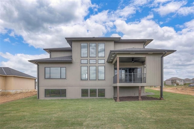 back of house featuring a lawn and ceiling fan