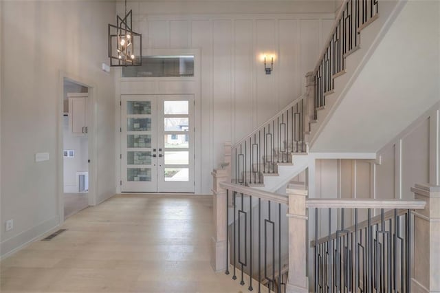 entryway featuring stairs, french doors, wood finished floors, and visible vents