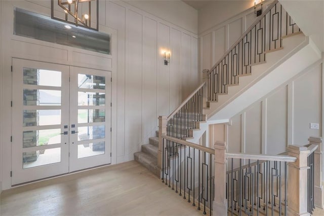 interior space featuring stairs, french doors, wood finished floors, and plenty of natural light