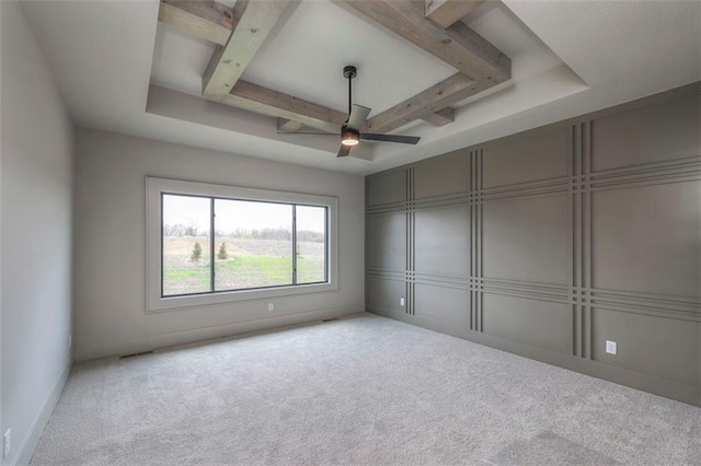 unfurnished room featuring visible vents, beamed ceiling, a ceiling fan, a decorative wall, and carpet floors