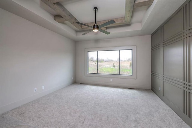 unfurnished bedroom featuring beamed ceiling, a ceiling fan, and light carpet