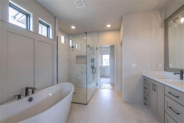 full bath featuring plenty of natural light, visible vents, a freestanding bath, and a stall shower