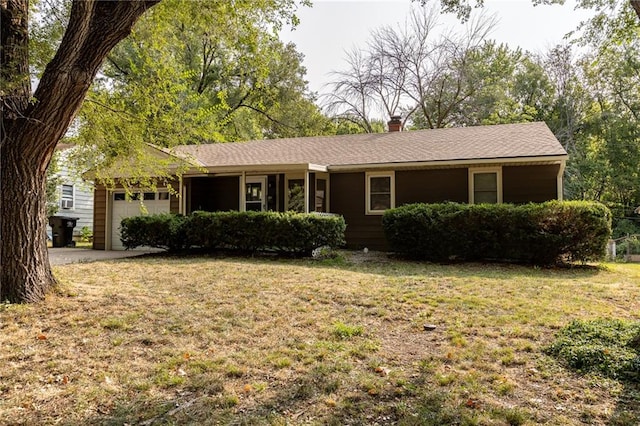 single story home featuring a garage and a front lawn