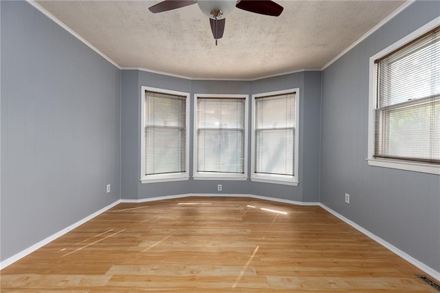 empty room with ceiling fan, ornamental molding, light hardwood / wood-style floors, and a textured ceiling