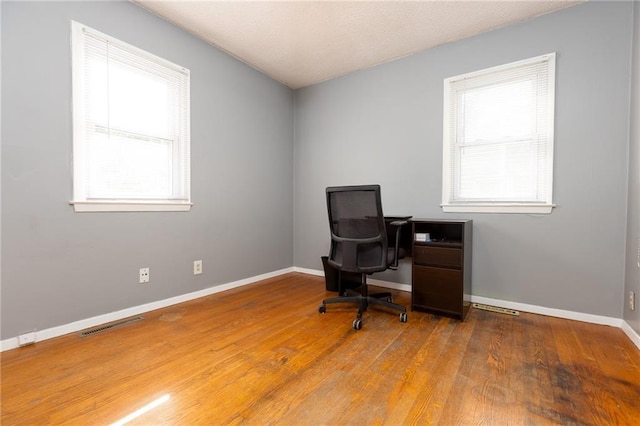 office area with hardwood / wood-style flooring and plenty of natural light