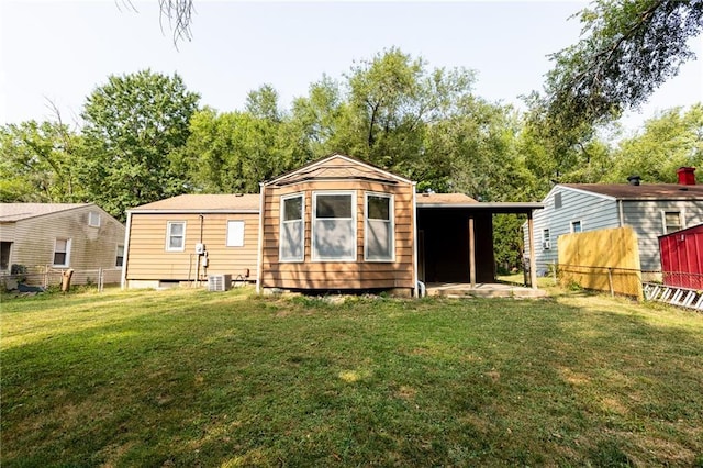 rear view of property with a lawn and central air condition unit