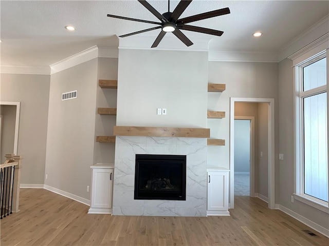 unfurnished living room featuring a wealth of natural light, crown molding, visible vents, and a tiled fireplace