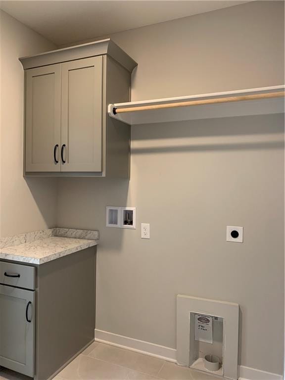 washroom featuring cabinet space, light tile patterned floors, baseboards, hookup for a washing machine, and hookup for an electric dryer