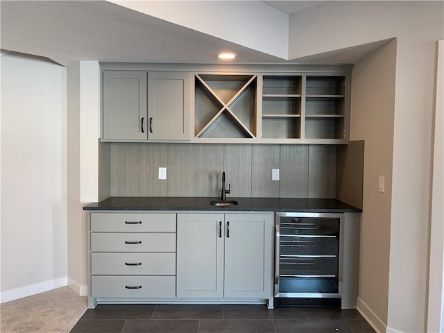 bar with wet bar, beverage cooler, a sink, and baseboards