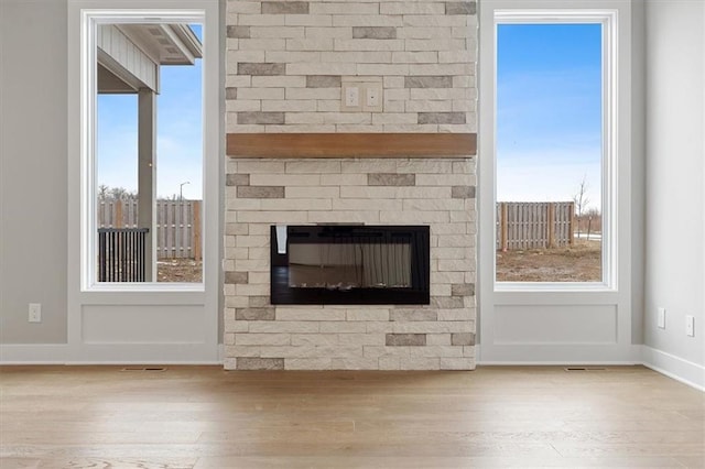 details with hardwood / wood-style flooring and a brick fireplace