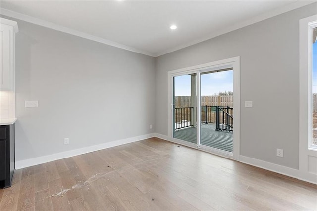 unfurnished living room featuring ornamental molding and light wood-type flooring