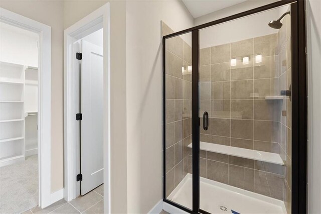 bathroom with tile patterned flooring and a shower with door