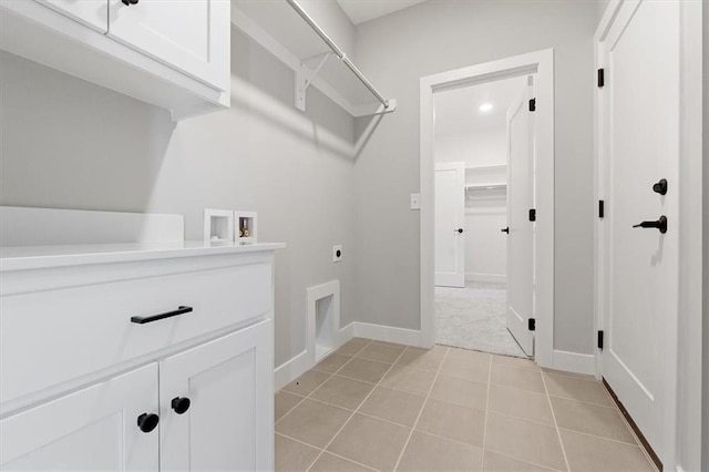 washroom featuring light tile patterned flooring, washer hookup, hookup for an electric dryer, and cabinets