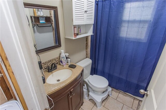 bathroom with curtained shower, tile patterned flooring, vanity, and toilet