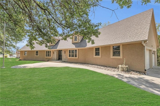 rear view of property with a garage and a yard