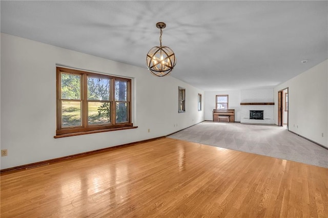 unfurnished living room with light hardwood / wood-style flooring and an inviting chandelier