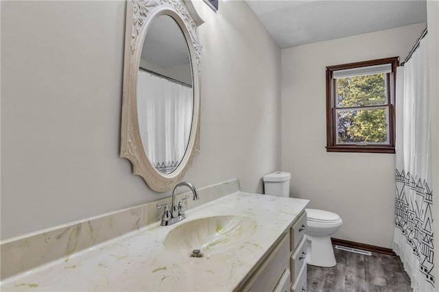 bathroom with vanity, toilet, and hardwood / wood-style floors