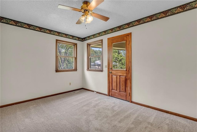 carpeted spare room with a textured ceiling and ceiling fan