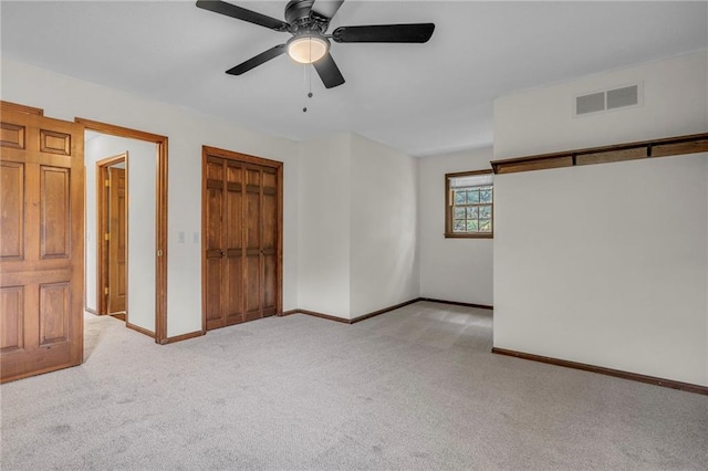 unfurnished bedroom featuring light colored carpet and ceiling fan