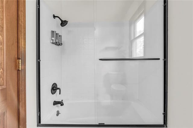 bathroom with combined bath / shower with glass door