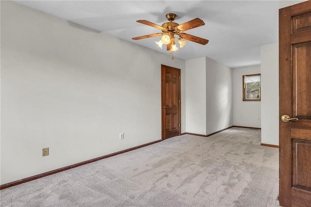 spare room with light colored carpet and ceiling fan