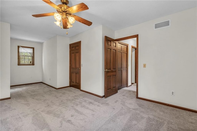 unfurnished bedroom featuring light colored carpet and ceiling fan