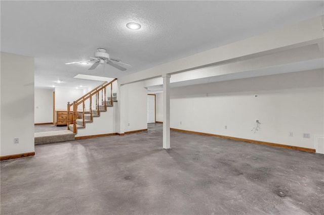 basement featuring a textured ceiling and ceiling fan