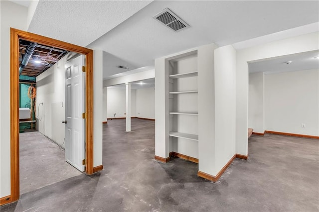 basement with built in features and a textured ceiling