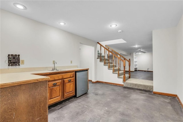 kitchen with stainless steel refrigerator, concrete floors, and sink