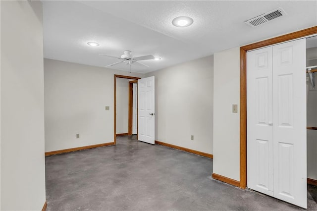 unfurnished room featuring concrete flooring, ceiling fan, and a textured ceiling