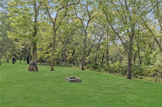 view of home's community with a lawn and an outdoor fire pit