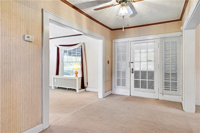 entrance foyer featuring ceiling fan, ornamental molding, and light colored carpet