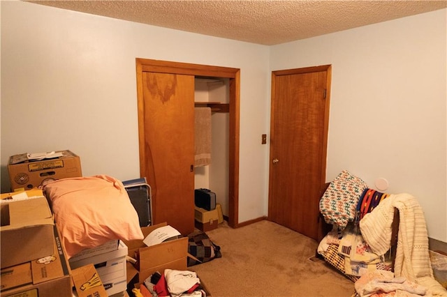 bedroom with a closet, light carpet, and a textured ceiling