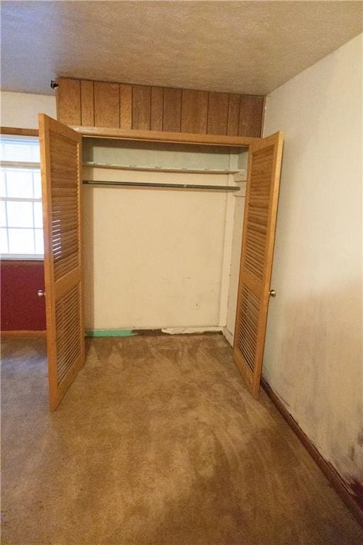 unfurnished bedroom featuring a closet, carpet flooring, and a textured ceiling