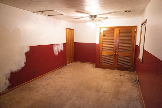 unfurnished bedroom featuring light carpet, a textured ceiling, and ceiling fan