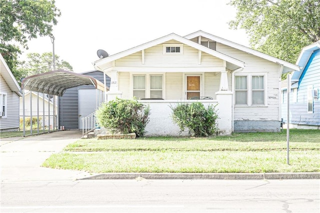 bungalow with a porch, a carport, and a front lawn