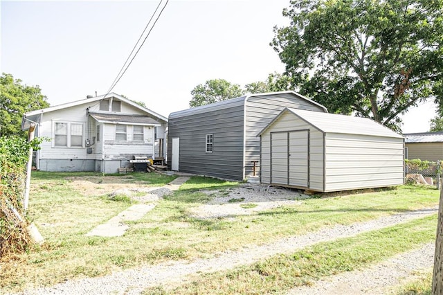 back of property with a storage shed and a yard