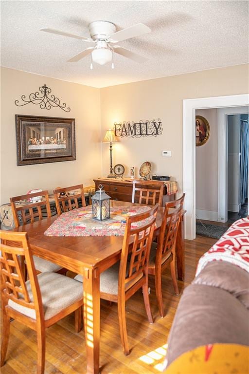 dining room featuring a textured ceiling, ceiling fan, and hardwood / wood-style flooring