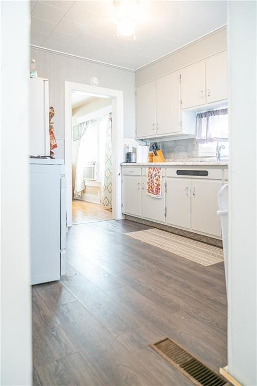 kitchen with dark wood-type flooring and white cabinets