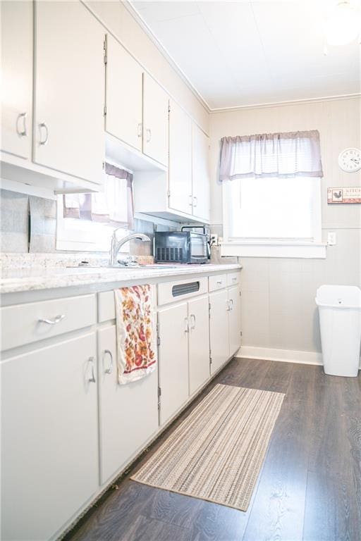 kitchen with ornamental molding, dark wood-type flooring, and white cabinetry