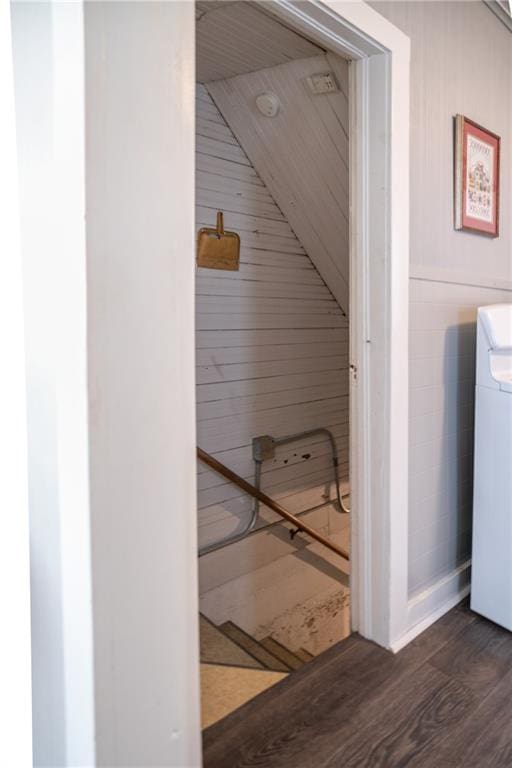 interior space featuring washer / clothes dryer, wood walls, and wood-type flooring