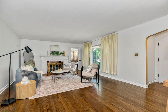 sitting room featuring hardwood / wood-style floors and a brick fireplace