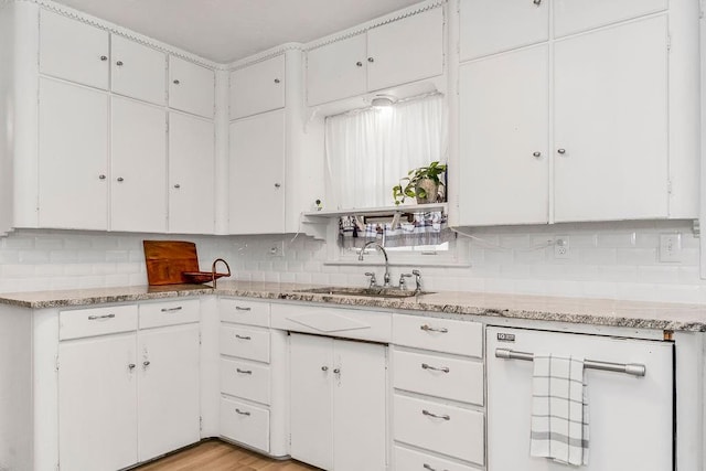 kitchen featuring white cabinetry, sink, light hardwood / wood-style flooring, and tasteful backsplash