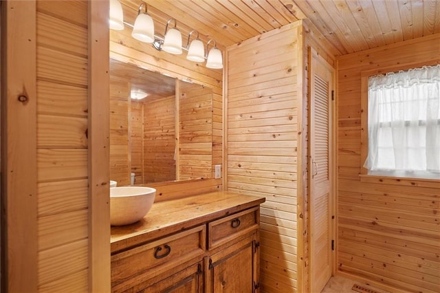 bathroom featuring vanity, wood ceiling, and wood walls