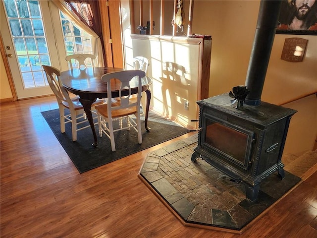 dining area featuring wood-type flooring and a wood stove