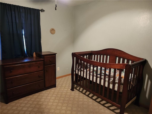 bedroom featuring a nursery area and light colored carpet