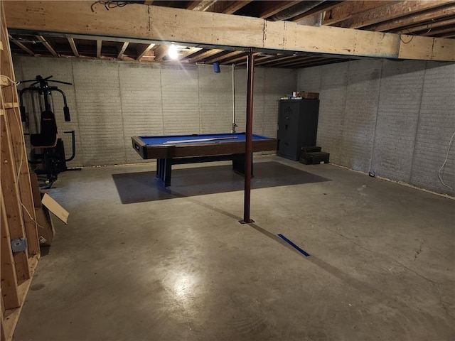 basement featuring billiards and brick wall