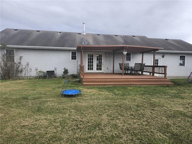 rear view of house with a wooden deck, a lawn, and central AC unit