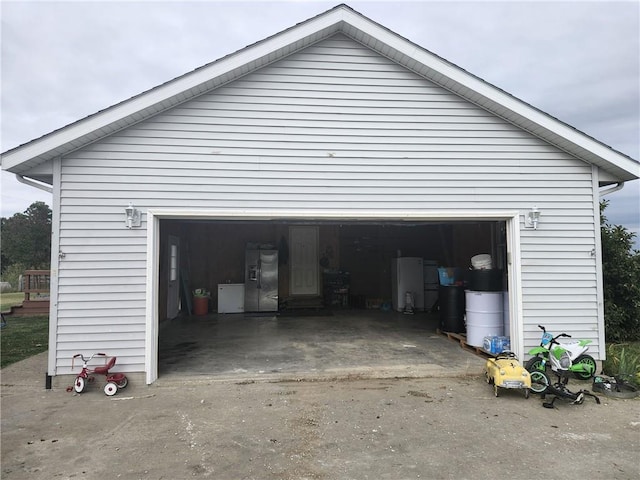 garage featuring stainless steel fridge with ice dispenser